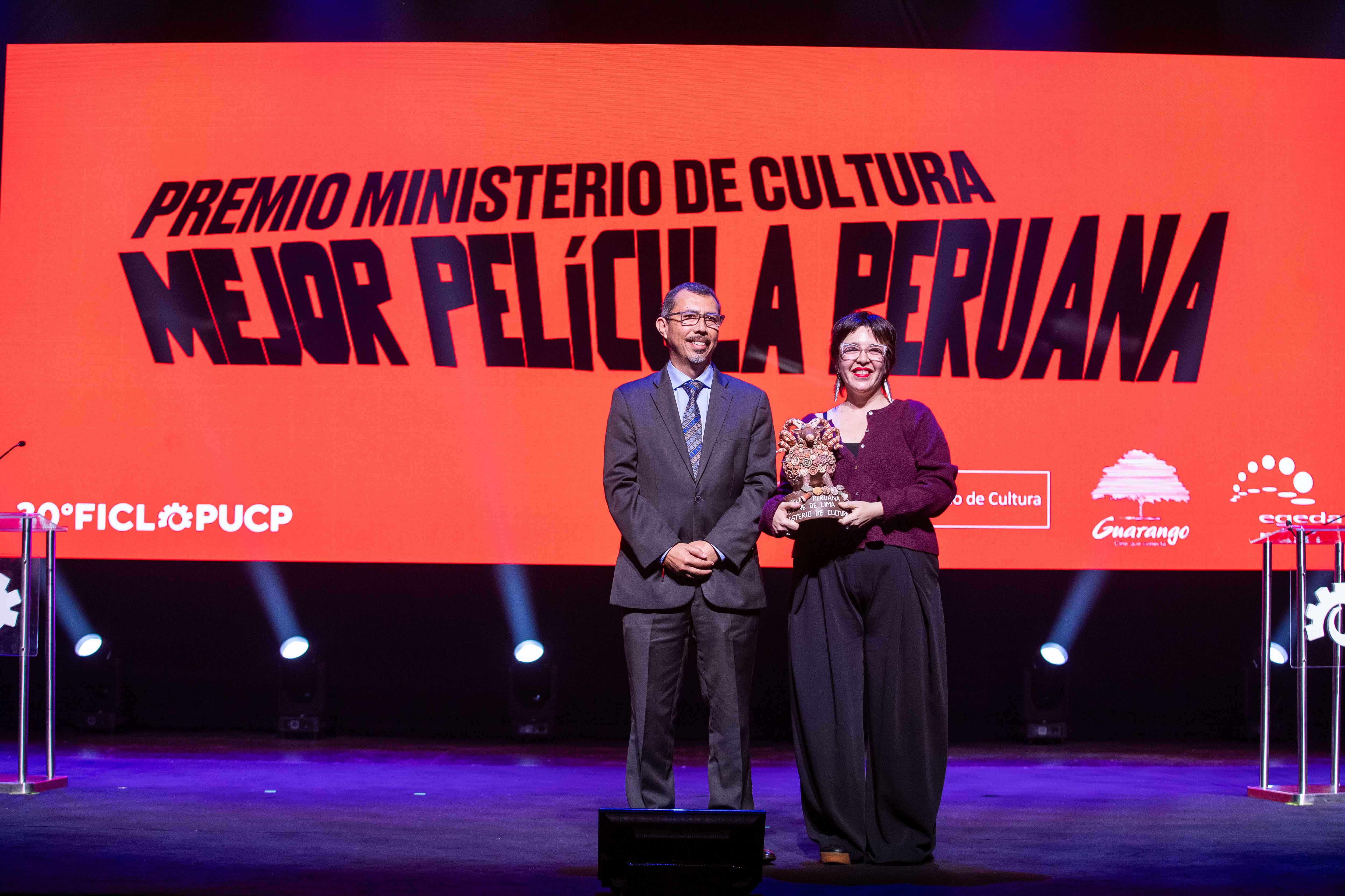 Carlos Alberto Solano Chuquiure, Director general de Industrias Culturales y Artes, entrega el premio a Luisa García Alva